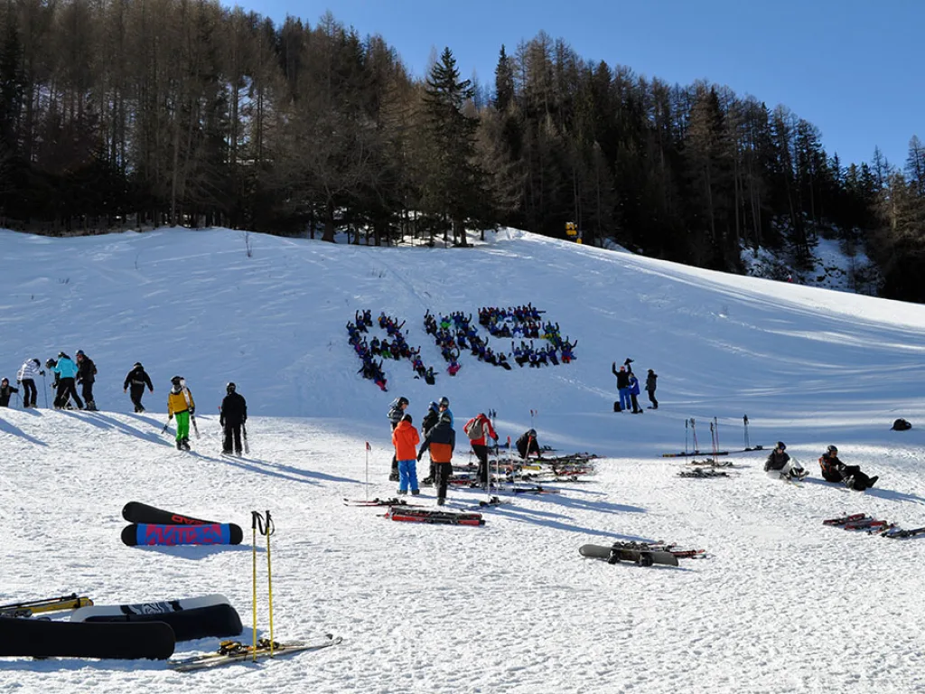 Blick über die Piste auf den aus Personen gelegten Schriftzug ARS.